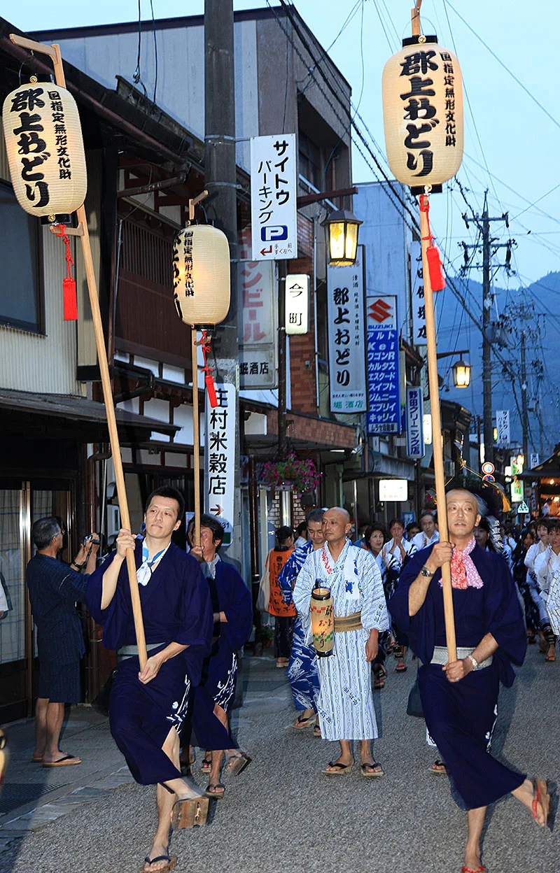 郡上踊行列中的參加者穿著浴衣，手持郡上おどり燈籠走過街道