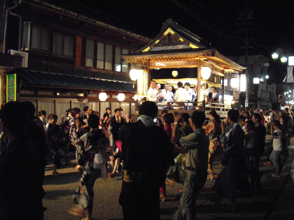 郡上八幡夜間的郡上踊,參加者圍繞燈光照明的囃子屋台跳舞
