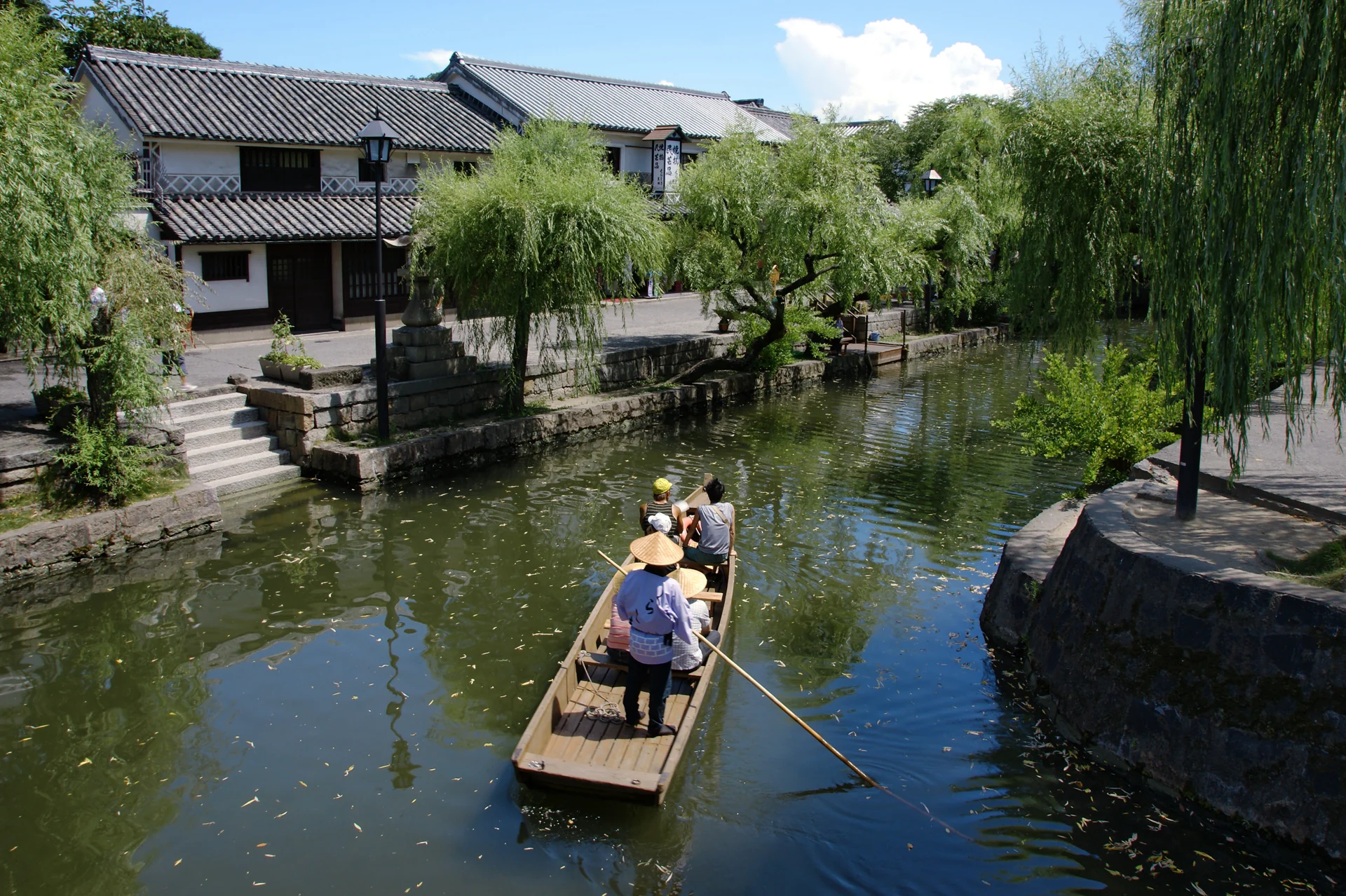 倉敷川舟行經白牆藏屋與柳樹旁的河岸