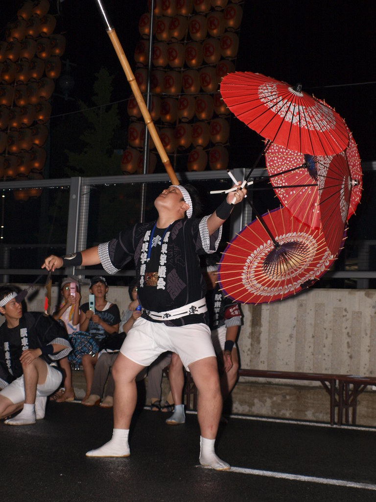 2012年秋田竿燈祭的演技,操竿者以額頭承竿,手持紅傘。