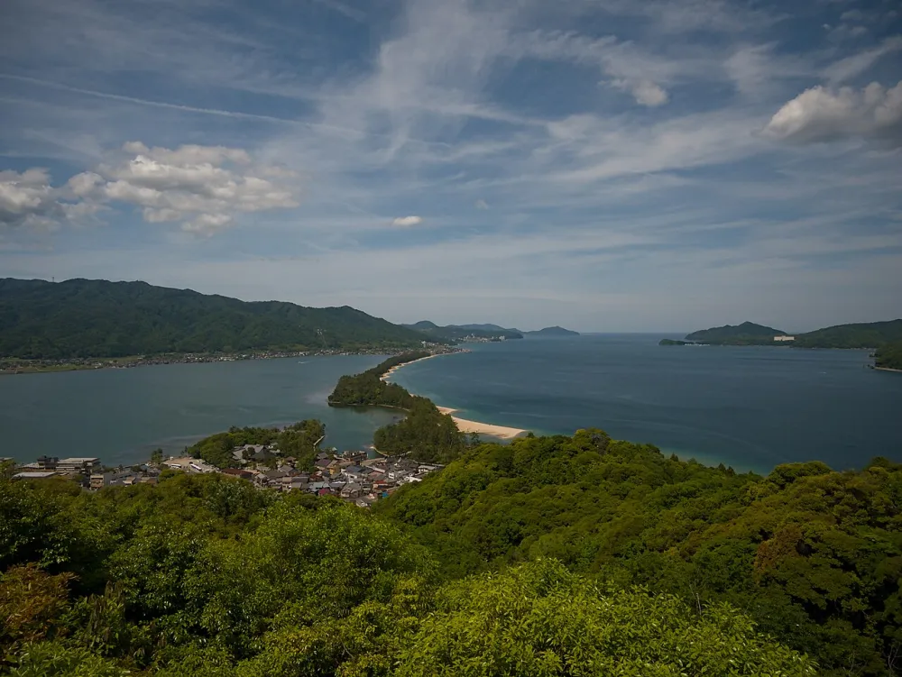從山坡俯看天橋立沙洲,前方是綠色樹林與兩側海灣