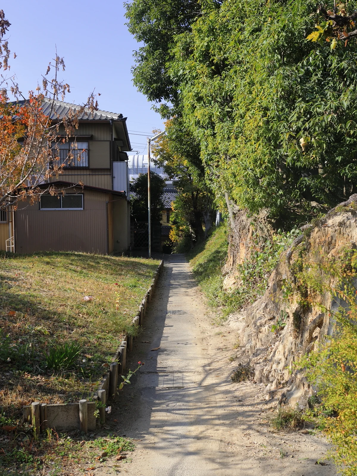 有松絞小路的狹窄坡道與階梯，兩側有石牆與住宅