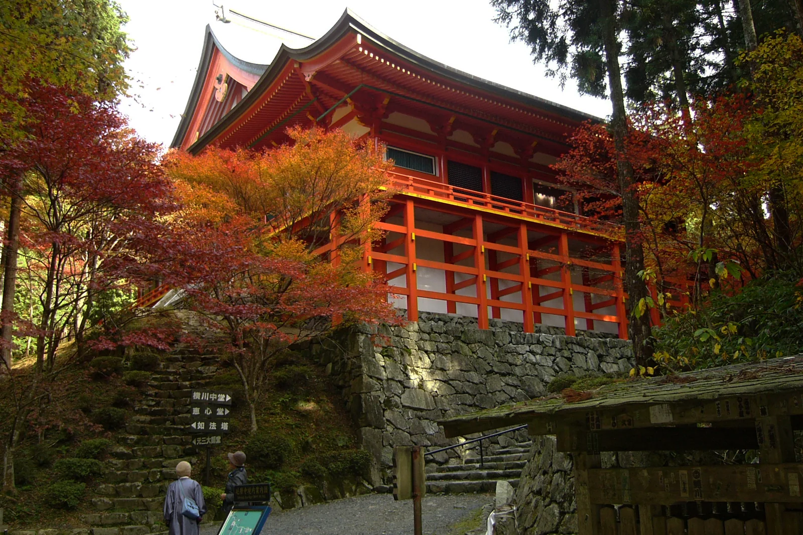 橫川中堂朱色舞台造建築，周圍有紅黃秋葉與石階