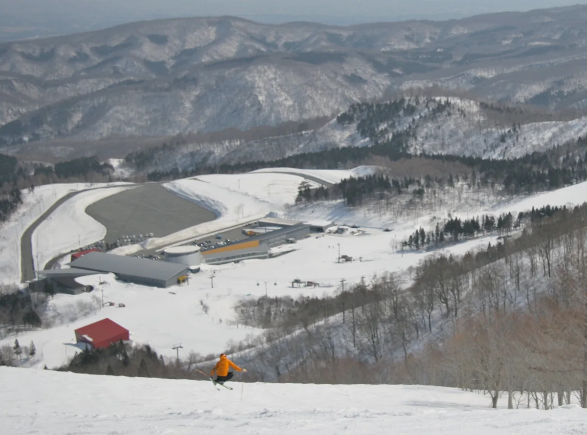 從夏油高原C1雪道俯瞰山麓雪場建築、停車場與群山