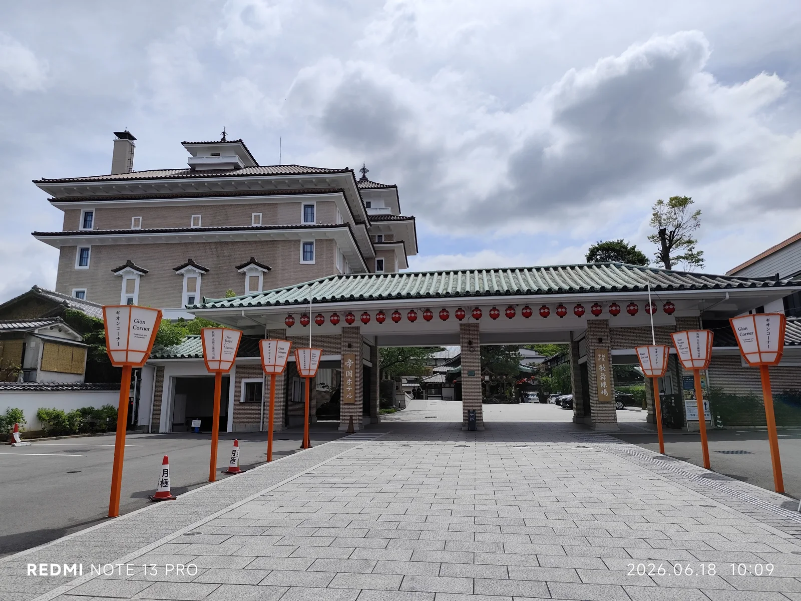 花見小路旁祇園甲部歌舞練場入口,橘色Gion Corner燈籠立在大門兩側,後方可見帝國酒店京都。