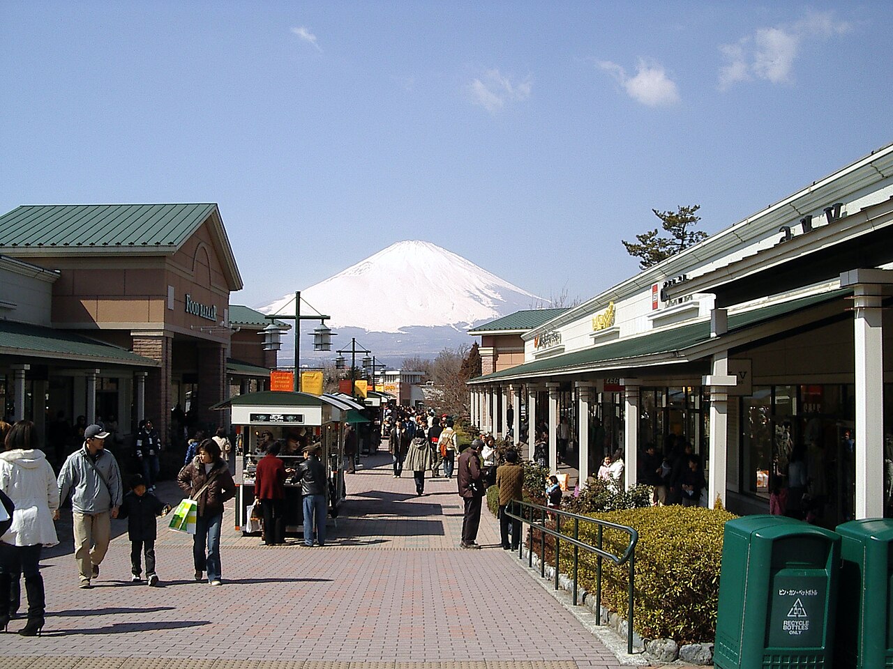 御殿場Outlet戶外購物街兩側的商店、步行旅客與遠方積雪富士山