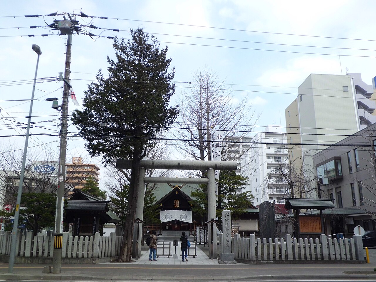 北海道神宮頓宮的石鳥居與後方社殿,周圍是市區建築
