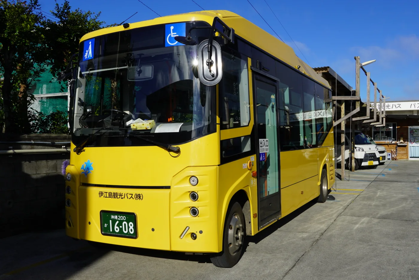 黃色的伊江島觀光巴士停在道路旁,車頭有輪椅標誌