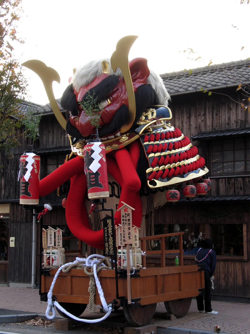 唐津くんち米屋町曳山,紅色酒呑童子首級與金紅色頭盔重疊,下方保留台車和綱索