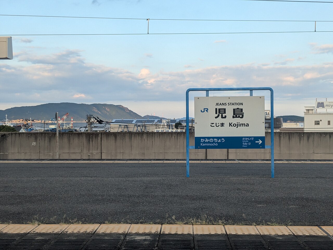 JR児島站月台上的児島站名牌與遠方山景