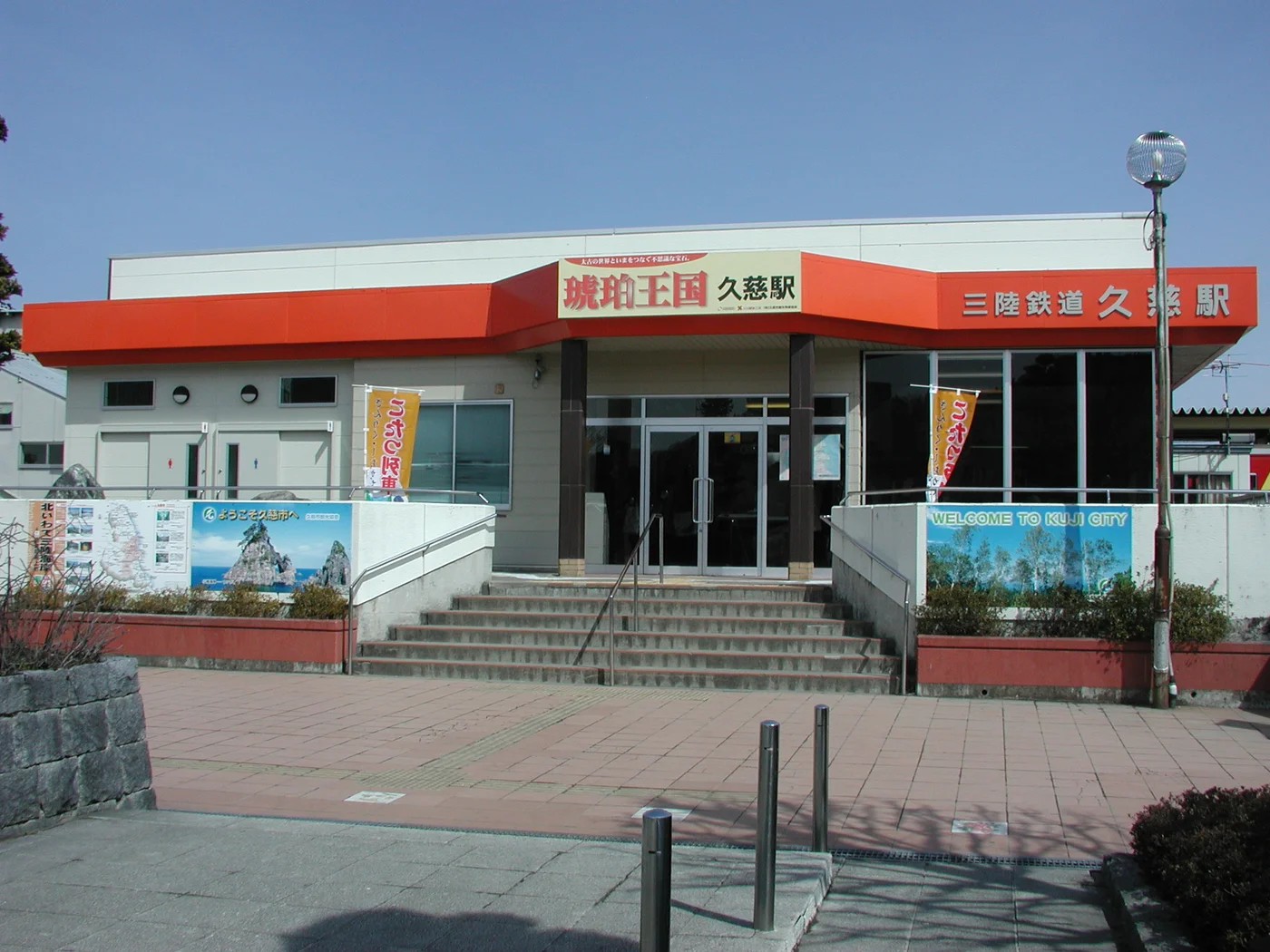 三陸鐵道久慈站的紅色站房、站名招牌與正面入口階梯