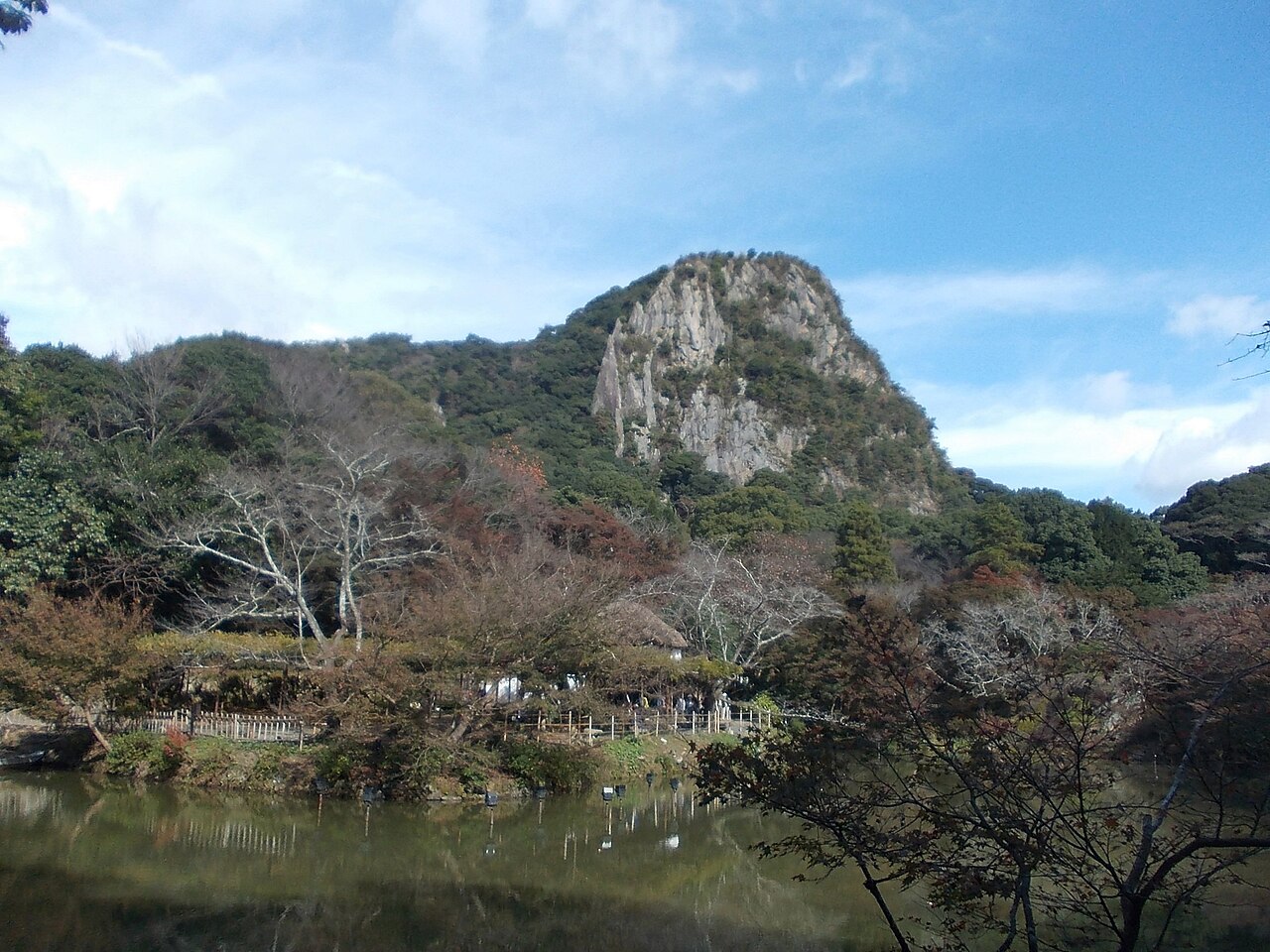 池水與秋季樹林後方的御船山岩壁