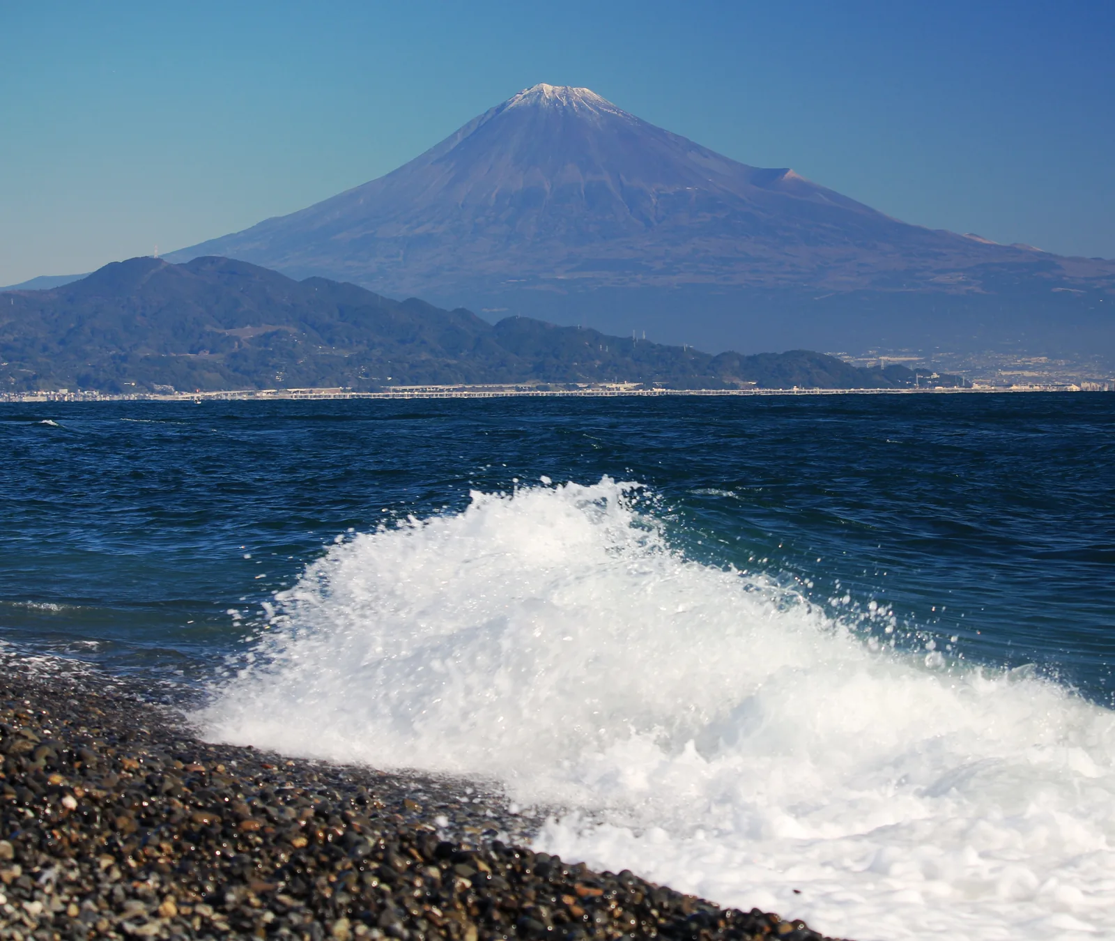 三保松原礫石海岸的白浪,遠方為積雪富士山