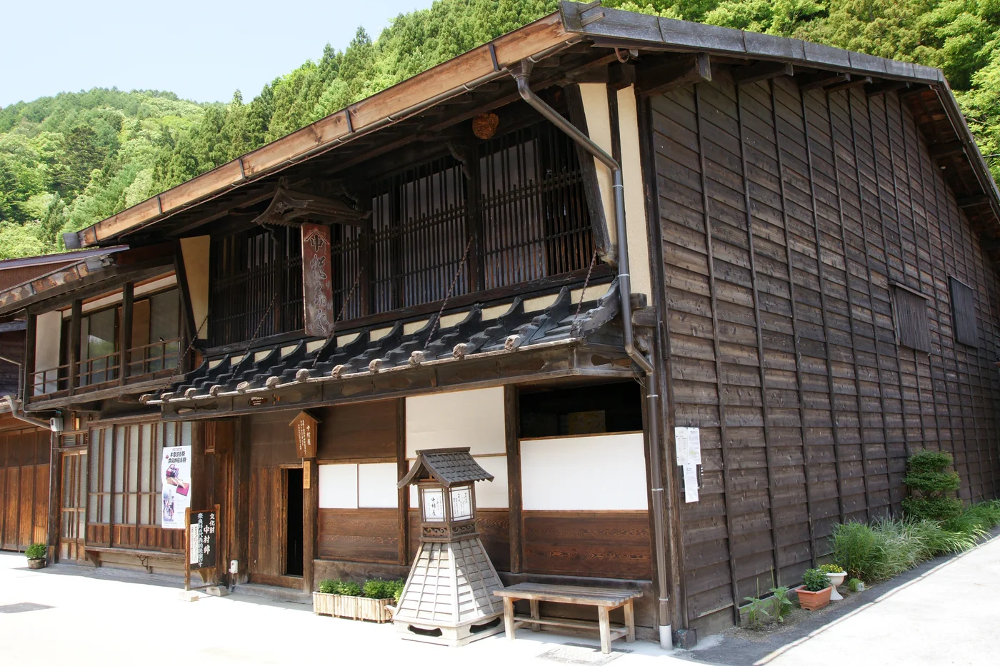 中村邸的二層木造外觀,正面有木格、深屋簷與入口,右側是板牆