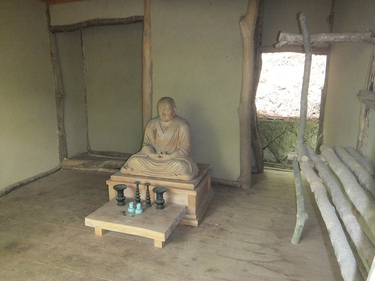 西行庵內部的木地板、梁柱與坐姿僧人塑像