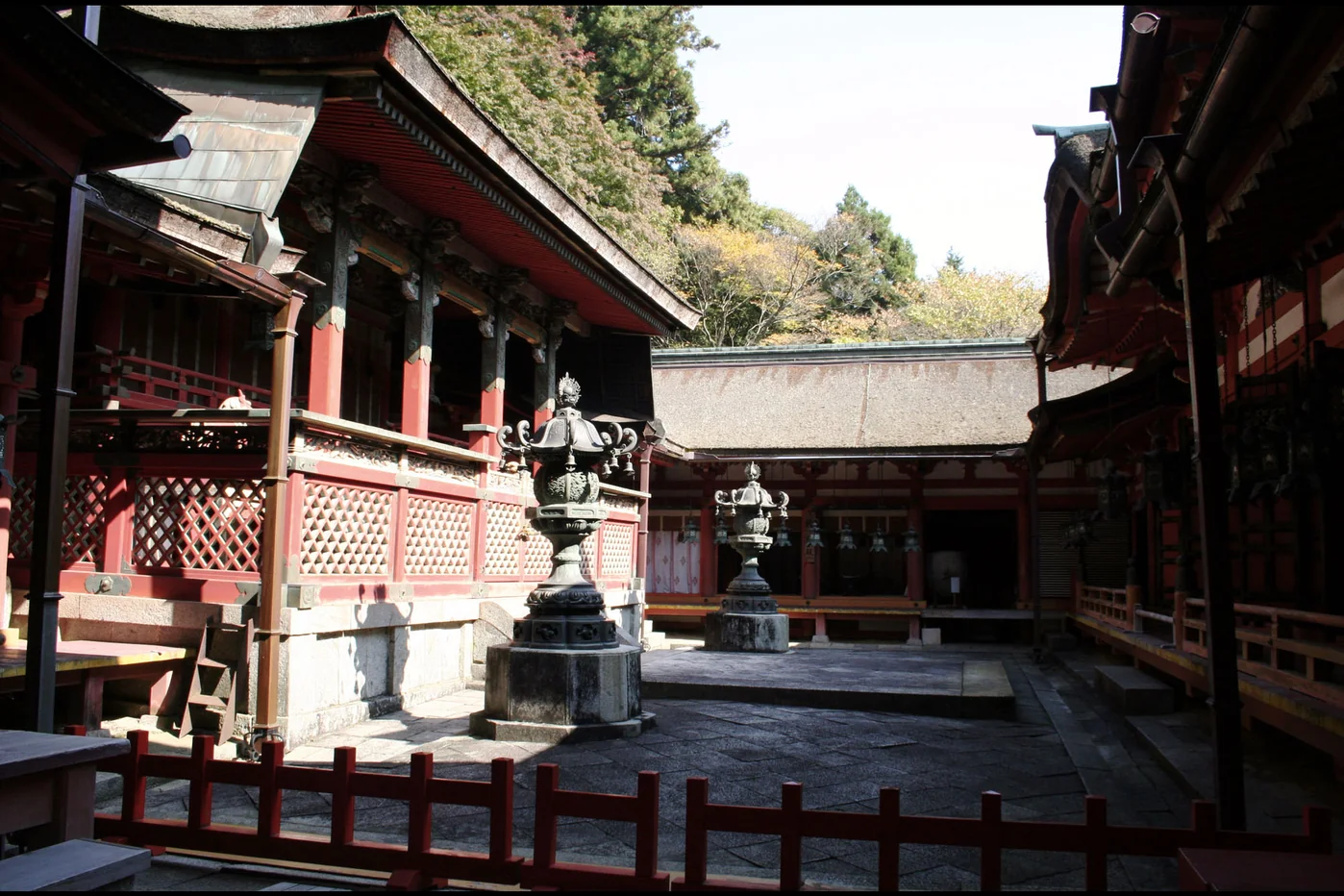 談山神社朱色社殿圍成中庭，前方排列燈籠，檜皮屋頂隨山坡錯落。
