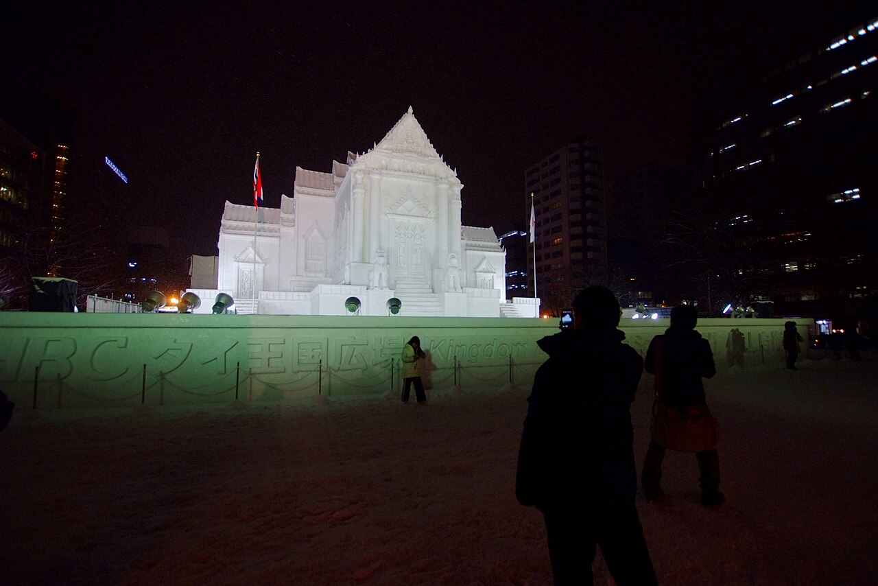 夜間照明下的大通會場泰國寺院大型雪雕,前方有參觀者