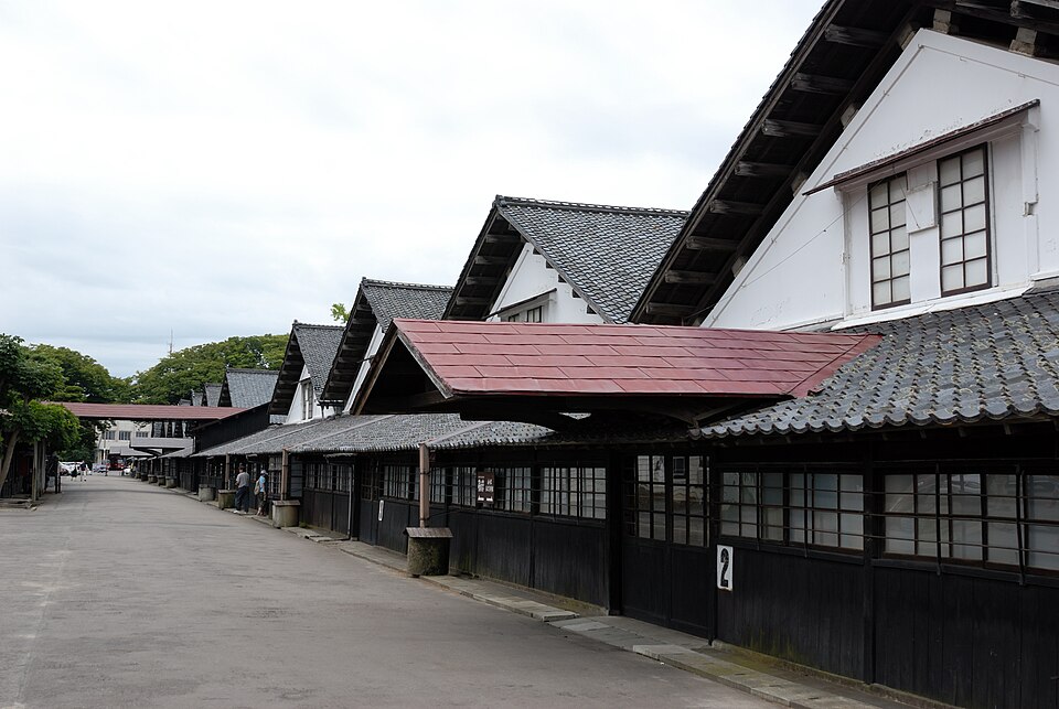 山居倉庫沿通道排列的白壁、黑色木板立面與瓦屋頂。